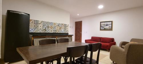 a living room with a wooden table and a red couch at Aldeias Guajiru Apart in Trairi