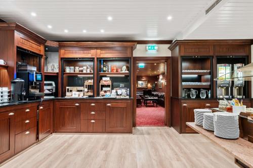 une cuisine avec des placards en bois et une salle à manger dans l'établissement Best Western Laegreid Hotell, à Sogndal