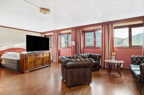 a living room with a couch and a television at Best Western Laegreid Hotell in Sogndal