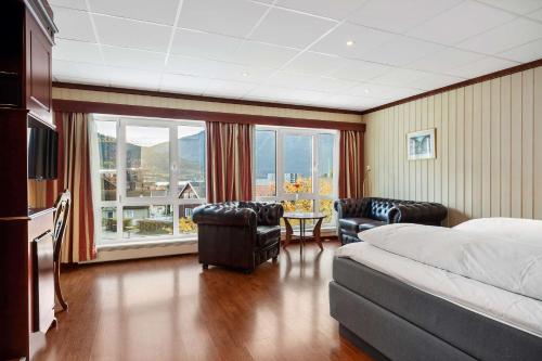 Habitación de hotel con cama, sillas y ventana grande. en Best Western Laegreid Hotell en Sogndal