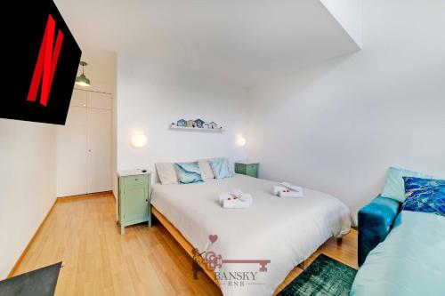 una camera con un letto bianco e un divano blu di CENTRAL & BRIGHT Apartment on two floors 'TURQUOISE' -By EasyLife Swiss a Lugano