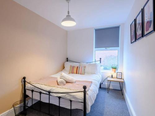 a bedroom with a bed in a room with a window at Magna Carta Cottage in Lincolnshire