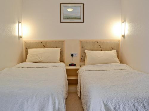 two beds sitting next to each other in a room at The Stables in Llannon