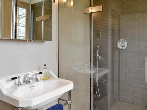 een badkamer met een wastafel en een douche bij Holly Cottage in Pett