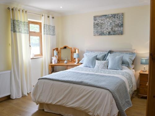 una camera da letto con un grande letto con cuscini blu di Russet a Ulrome
