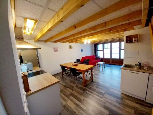 eine Küche und ein Wohnzimmer mit einem Tisch im Zimmer in der Unterkunft Maison de ville au cœur du quartier historique in Oloron-Sainte-Marie