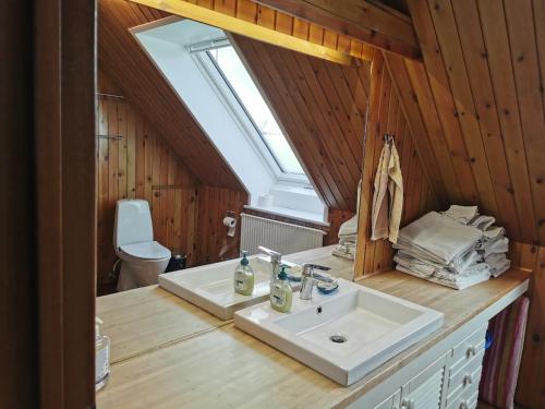 La salle de bains est pourvue d'un lavabo et de toilettes. dans l'établissement Annys Bed & Breakfast, à Sunds