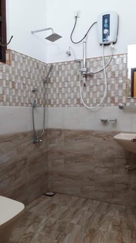 a bathroom with a shower and a sink at Blue Point Rest & Villa in Tangalle
