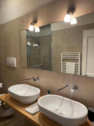 Baño con 2 lavabos y espejo en Casa le Querce, en Castiglione del Lago