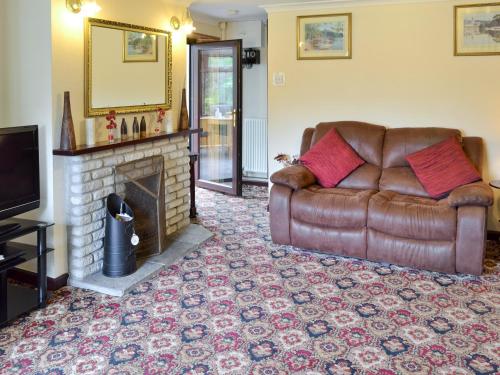 a living room with a couch and a fireplace at Coombe End Cottage in Carnbrea