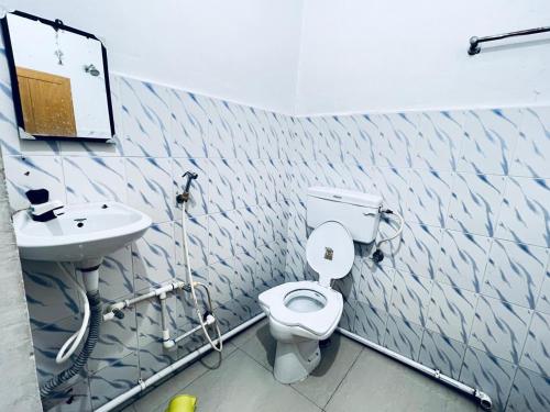 a bathroom with a toilet and a sink at HOTEL RAJGIR INTERNATIONAL in Rājgīr
