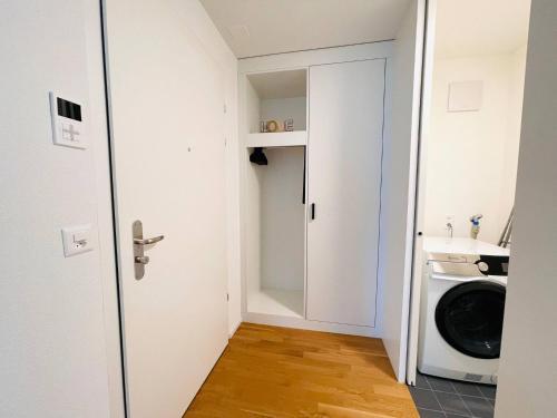 a small laundry room with a washer and dryer at New building with balcony closecentrefreeparkingsmarttv in St. Gallen