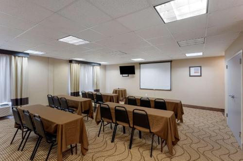 a conference room with tables and chairs and a screen at Comfort Inn & Suites Woods Cross - Salt Lake City North in Woods Cross