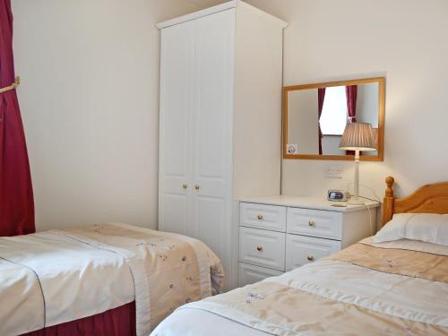 a bedroom with two beds and a mirror and a dresser at Tremafon in Barmouth