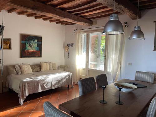 1 dormitorio con cama, mesa y comedor en Casa le Querce, en Castiglione del Lago