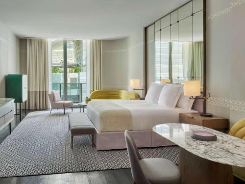 a hotel room with a large bed and a table at SLS LUX Brickell in Miami