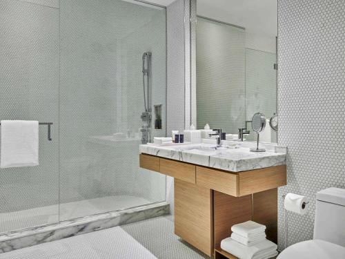 a bathroom with a sink and a shower and a toilet at SLS LUX Brickell in Miami