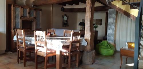 a dining room with a table and wooden chairs at EL CAMPANARIO in Guinicio