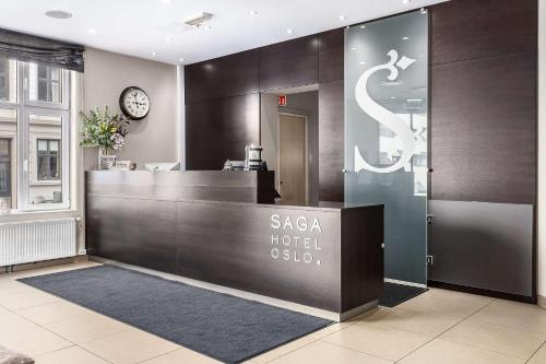 a hotel lobby with a reception desk and a clock at Saga Hotel Oslo; BW Premier Collection in Oslo