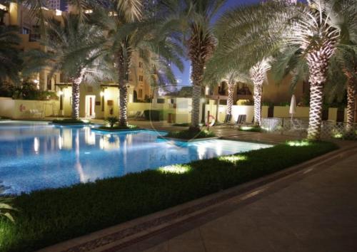 einen großen Pool mit Palmen und Lichtern in der Unterkunft Ultra Luxury Downtown - Full Burj Khalifa View - 5 Min Walk To Dubai Mall! in Dubai