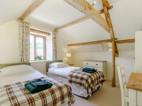 a bedroom with two beds and a table and a window at The Wheel House in Potto