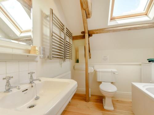uma casa de banho branca com um lavatório e um WC em The Wheel House em Potto