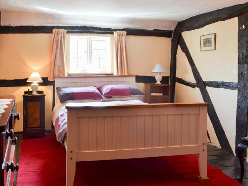 a bedroom with a bed and a window at Tudor Cottage in Romsey