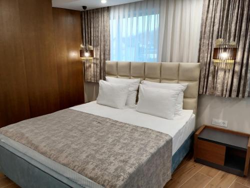Un dormitorio con una cama grande y una ventana en Hotel La More, en Srebrenik