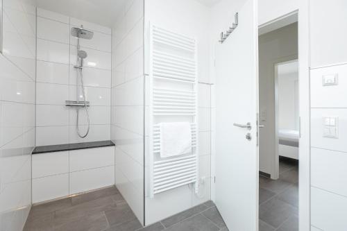 ein weißes Bad mit einer Dusche und einer Glastür in der Unterkunft Brenkenhagener Weg 4 Wohnung 7 in Grömitz