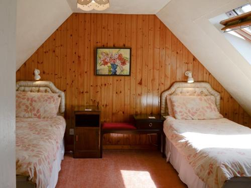 2 camas en un ático con paredes de madera en Achd en Nedd