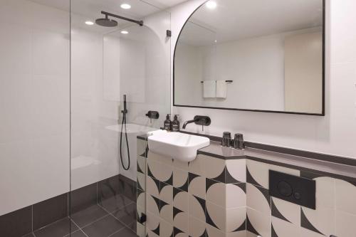 W łazience znajduje się umywalka i lustro. w obiekcie The Capitol Hotel Sydney w mieście Sydney