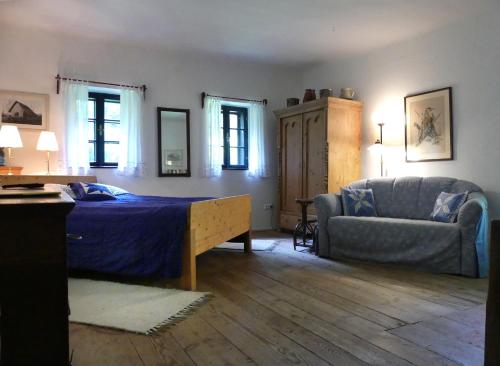 a bedroom with a bed and a couch and a chair at Haus Eveline in Gerersdorf bei Güssing