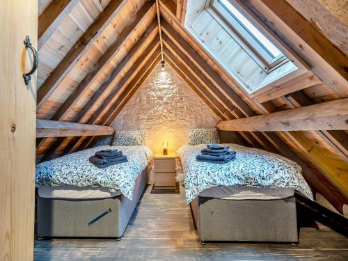 two beds in a attic bedroom with wooden ceilings at Pippin-uk41837 in Clevedon