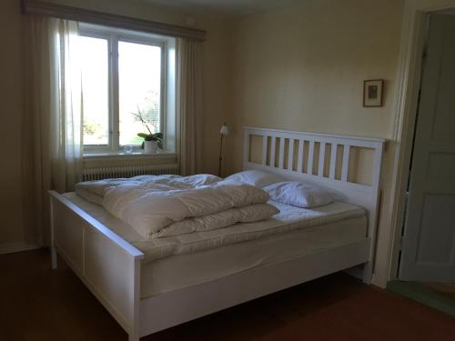 1 cama blanca con almohadas en el dormitorio en Sjöbredareds Gård en Hökerum