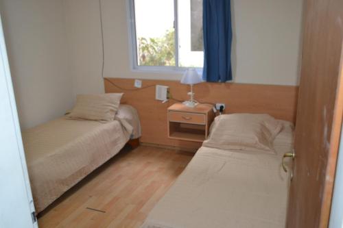 Un dormitorio pequeño con dos camas y una ventana. en Casa ideal hasta 7pax con cochera propia, en Mendoza