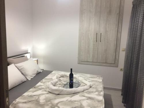 a bed with a bottle of wine on top of it at Maria's house in Diakopto