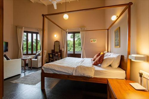 um quarto com uma grande cama de dossel num quarto em Fully AC 3BDHK villa with Jacuzzi pool and courtyard em Porvorim