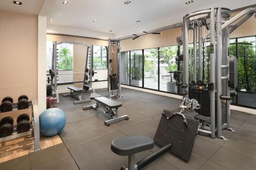 a gym with several treadmills and machines at PARKROYAL Suites Bangkok in Bangkok