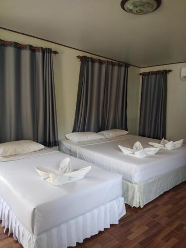 two white beds in a room with curtains at Mook Paradise Bungalow in Ko Mook