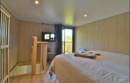 een slaapkamer met een groot bed en een balkon bij La Maison du Bonheur in Lons-le-Saunier