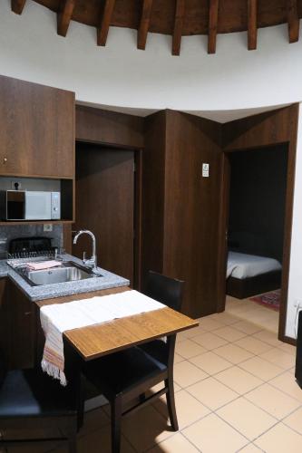 a kitchen with a sink and a table and a room at Alvão Village & Camping in Reguengo