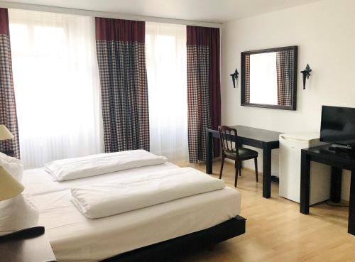 a bedroom with a bed and a desk with a computer at Apartment Rathausplatz - HOTEL FÜRSTENHOF in Kempten