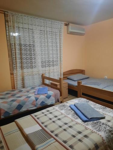 Cette chambre comprend 2 lits et une fenêtre. dans l'établissement LUG, à Belgrade