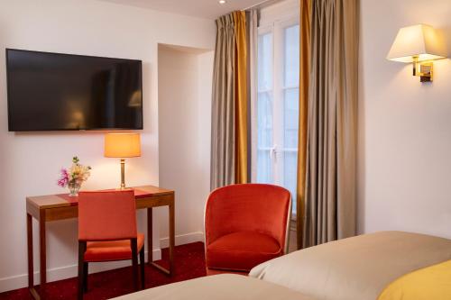 une chambre d'hôtel avec un lit, un bureau et des chaises dans l'établissement Hotel De Suede Saint Germain, à Paris