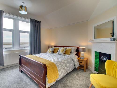 a bedroom with a bed and a fireplace at Heron House in Tweedmouth