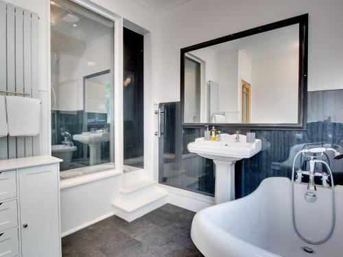uma casa de banho com uma banheira branca, um lavatório e uma banheira. em Heron House em Tweedmouth