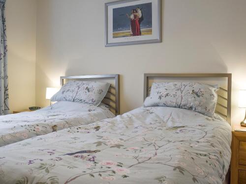 een slaapkamer met 2 bedden en een foto aan de muur bij 3 Greta Grove House in Keswick