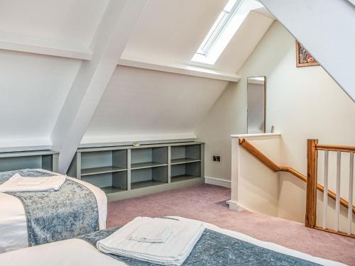 a attic bedroom with a bed and a skylight at Old School Mews in Shanklin