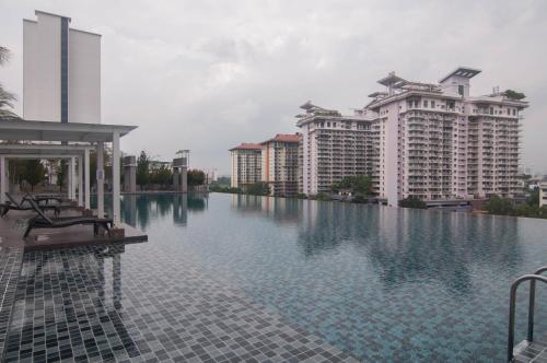 a large swimming pool with two tall buildings at Alam Sanjung Seksyen 22 @ Shah Alam by Idealhub in Shah Alam
