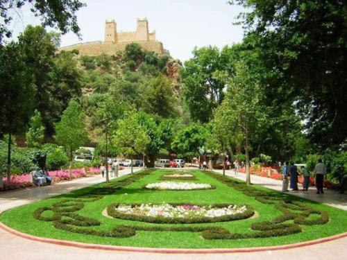 a garden with a clock in the middle of it at cosy appartement au Centre de la ville avec WIFI in Beni Mellal